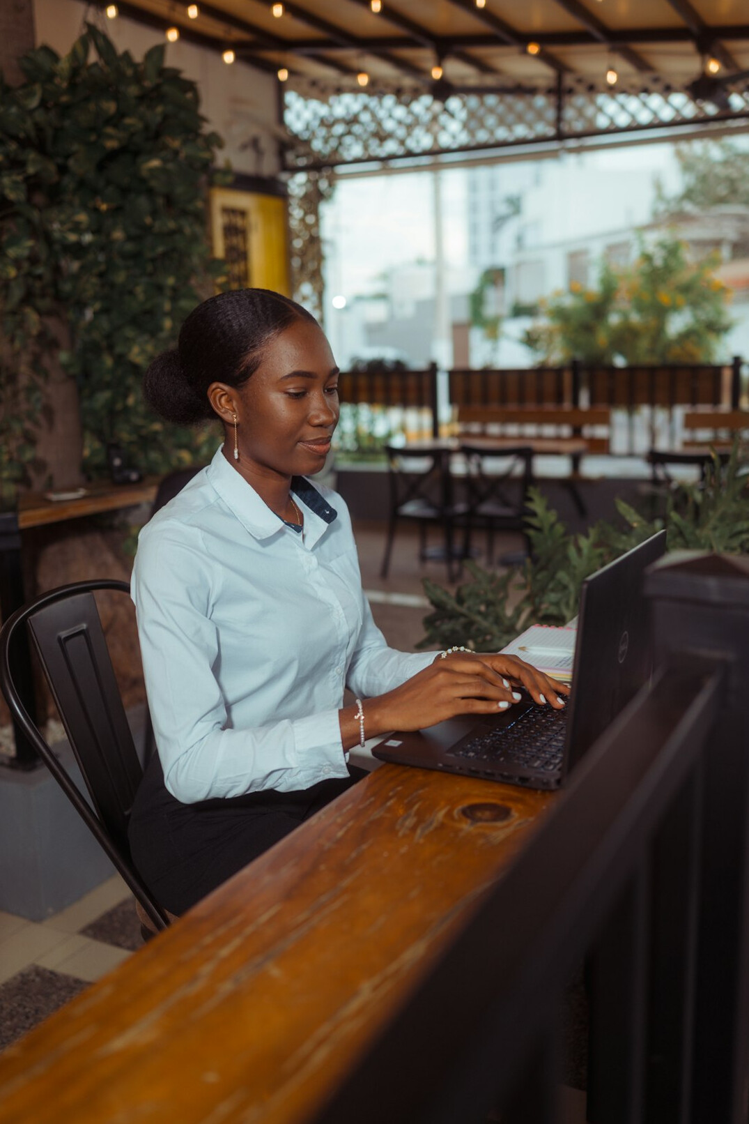 author typing on laptop in cafe